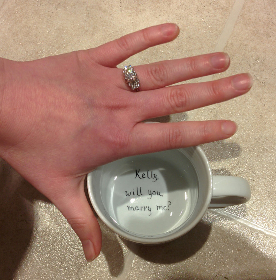 Proposal mug with "Kelly, will you marry me?" painted on the bottom.